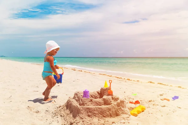 Schattig klein meisje spelen met zand op het strand — Stockfoto