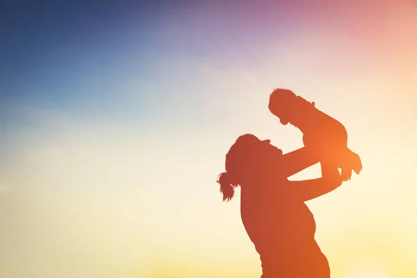 Mother and little baby play at sunset — Stock Photo, Image