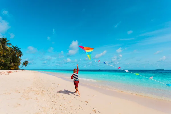 Tropik sahilde uçurtma uçan küçük çocuk — Stok fotoğraf