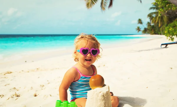 Schattig meisje beetje spelen met zand op strand — Stockfoto