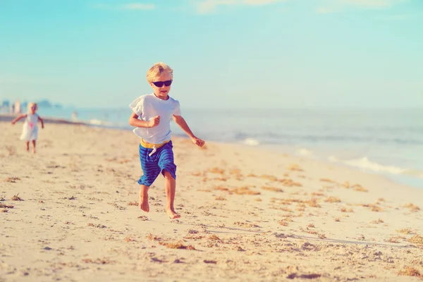 Mały chłopiec i dziewczynka działa na plaży — Zdjęcie stockowe