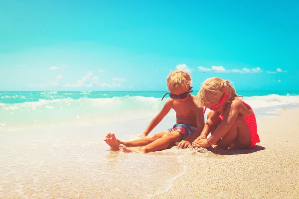 Kinderen spelen met zand op het zomerstrand — Stockfoto