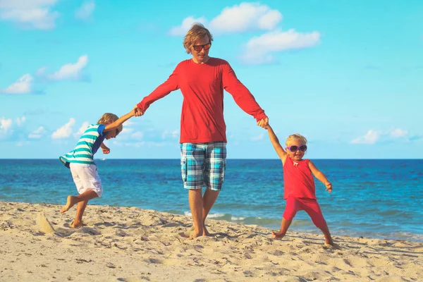 Vader en zoon en dochter spelen op strand — Stockfoto