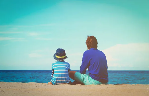 Pai e pequeno filho falando na praia — Fotografia de Stock