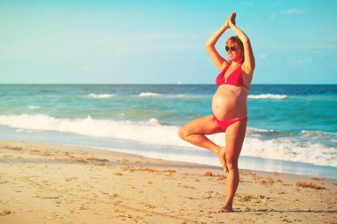 Hamile kadın pratik Yoga Beach