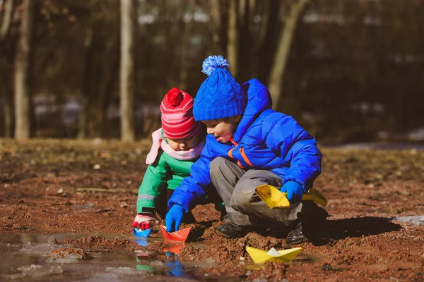 Little boy and toddler girl playing with water in spring — Stock Photo, Image