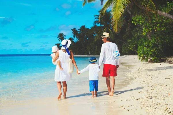 Gezin met twee kinderen lopen op strand — Stockfoto