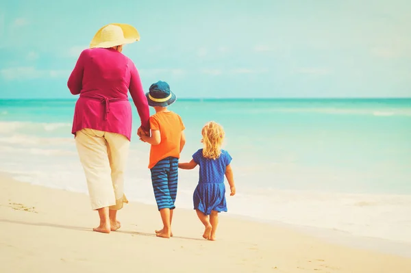 Gelukkig oma met kinderen - kleine jongen en meisje-op strand — Stockfoto