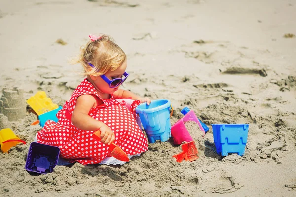 Mignonne petite fille jouer avec le sable sur la plage — Photo