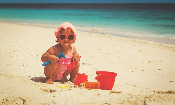 Χαριτωμένο κοριτσάκι παίζουν με άμμο στην παραλία — Φωτογραφία Αρχείου