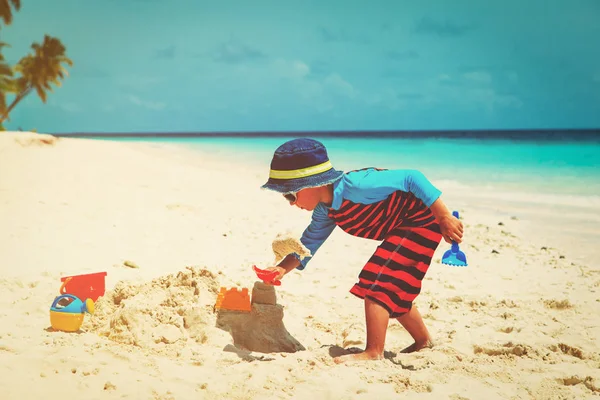 Kleine jongen spelen met zand op strand — Stockfoto