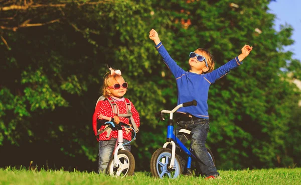 Kleiner Junge und kleines Mädchen auf Fahrrädern in der Natur — Stockfoto