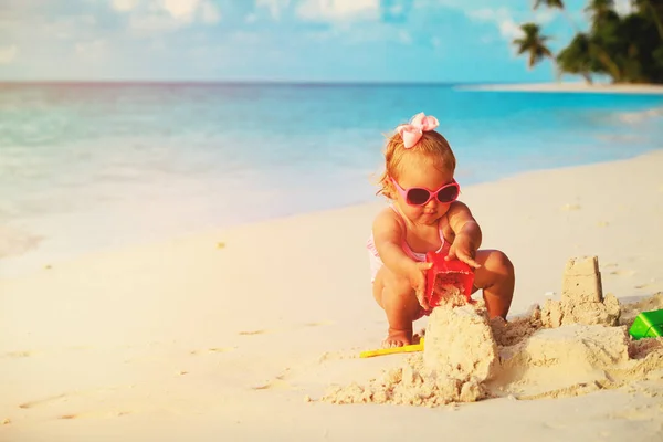 Schattig klein meisje spelen met zand op het strand — Stockfoto