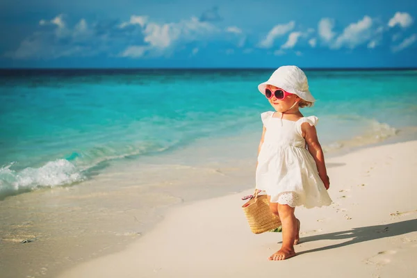 Счастливая милая маленькая девочка гуляет по песчаному пляжу — стоковое фото