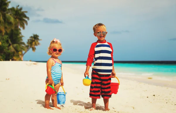 Kinderen spelen met zand op het zomerstrand — Stockfoto