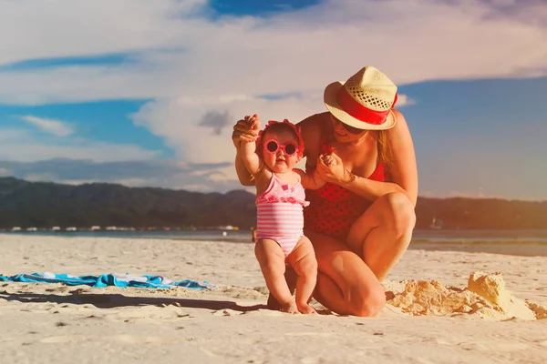 Matka hraje s roztomilý dcerkou na pláži — Stock fotografie