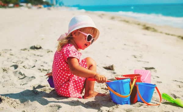 Cute little girl play with sand on beach — Stock Photo, Image