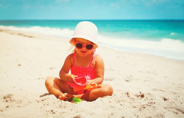 Cute little girl grać z piasku na plaży — Zdjęcie stockowe