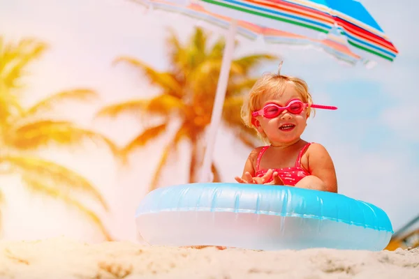 Cute little girl with toy floating ring at beach — Stock Photo, Image