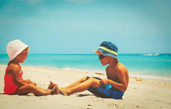 Malý chlapec a dívka baví na pláži — Stock fotografie