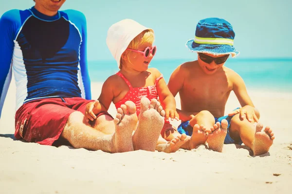 Otec, syn a dcera nohama na písečné pláži — Stock fotografie