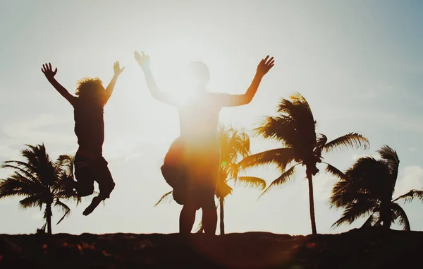 Feliz mãe e filho pulando se divertindo no pôr do sol — Fotografia de Stock