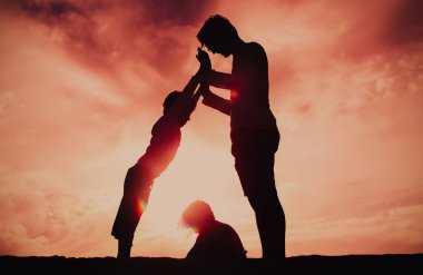 Baba ve iki çocuk günbatımı gökyüzü üzerinde oynama