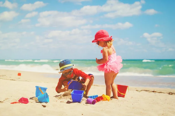 Crianças brincam com areia na praia de verão — Fotografia de Stock