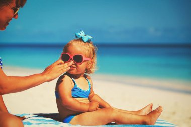 Anne kızın yüzünde güneş kremi krem uygulamak