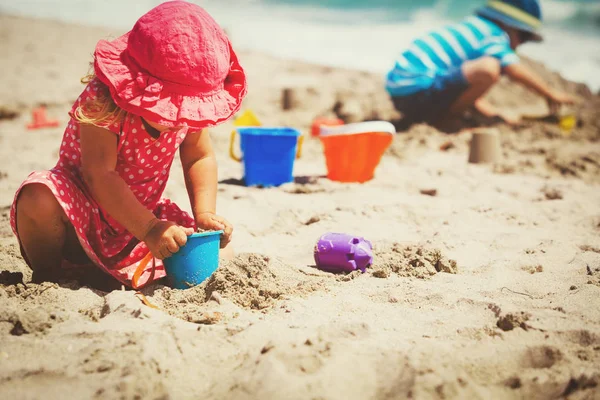 Kids play with sand on summer beach — Stock Photo, Image