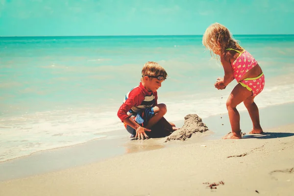 kids play with sand on summer beach