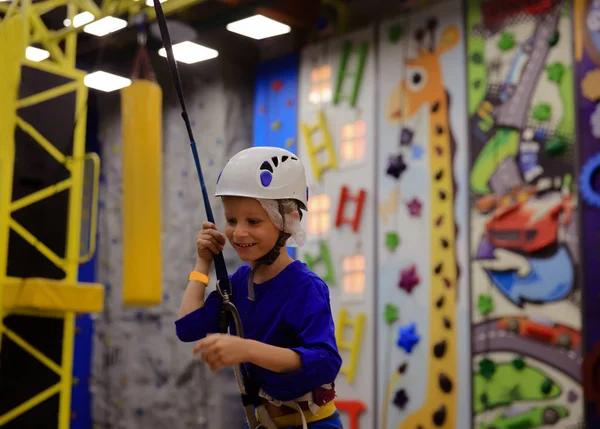Mały chłopiec ściankę wspinaczkową w centrum sportu — Zdjęcie stockowe