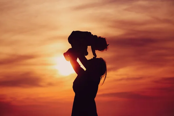 Mother and little daughter play at sunset — Stock Photo, Image