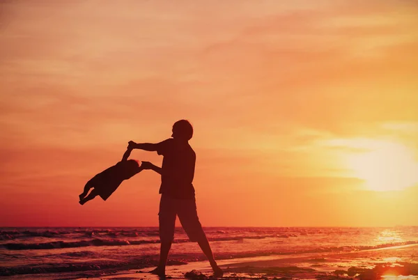 Pai e pequena filha silhuetas ao pôr do sol — Fotografia de Stock