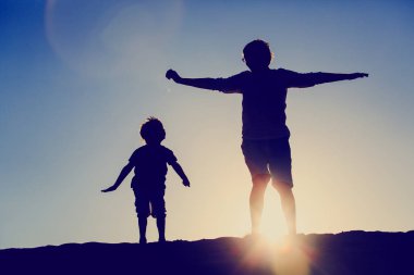 Baba ve oğul günbatımı gökyüzü atlama
