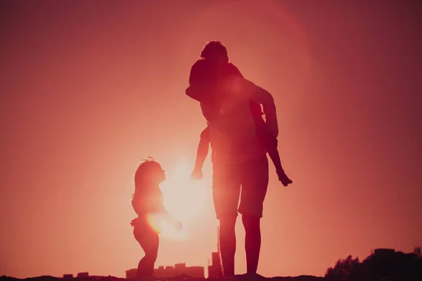 父亲与儿子和女儿剪影戏剧在日落时 — 图库照片