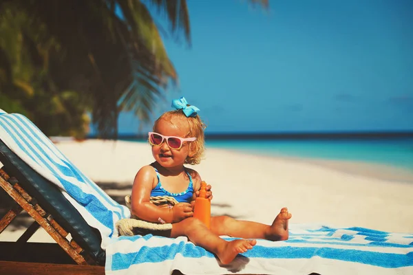 Schattig klein meisje met sunblock crème op strand — Stockfoto