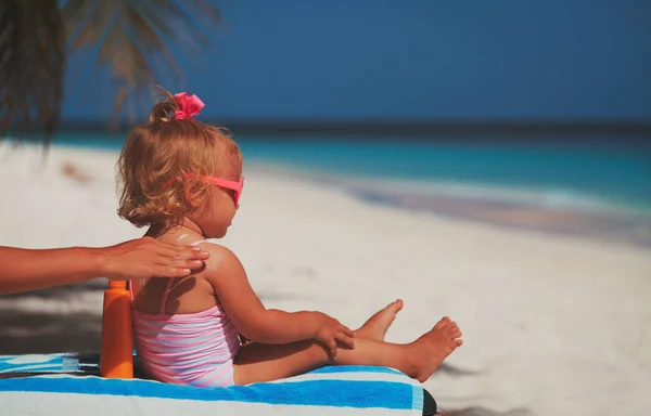 Mother applying sunblock cream on daughter shoulder — Stock Photo, Image