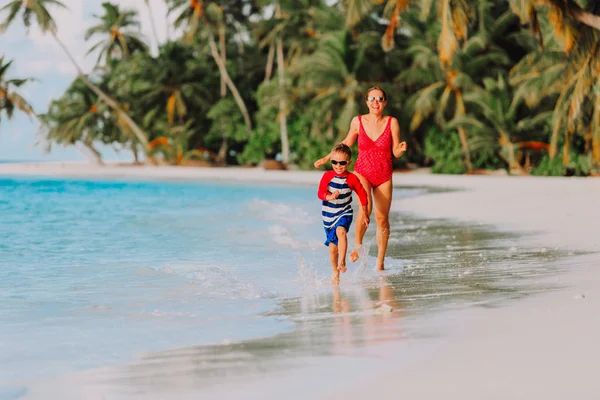 Matka i syn działa w wodzie na plaży — Zdjęcie stockowe