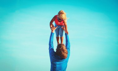 Baba ve küçük kız gökyüzünde oynuyorlar.