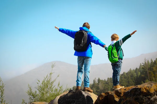 Feliz pai e filho caminhadas escalando nas montanhas — Fotografia de Stock