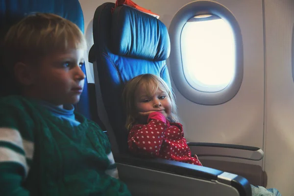 Niña y niño viajan en avión — Foto de Stock