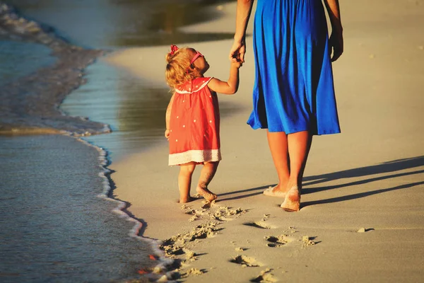 Mère et petite fille marchant sur la plage — Photo