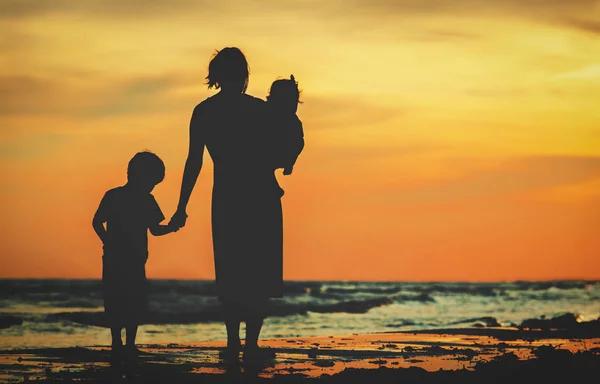 어머니와 두 아이 일몰 해변에 산책 — 스톡 사진