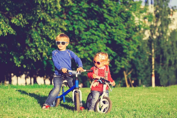Kleiner Junge und kleines Mädchen auf Fahrrädern in der Natur — Stockfoto