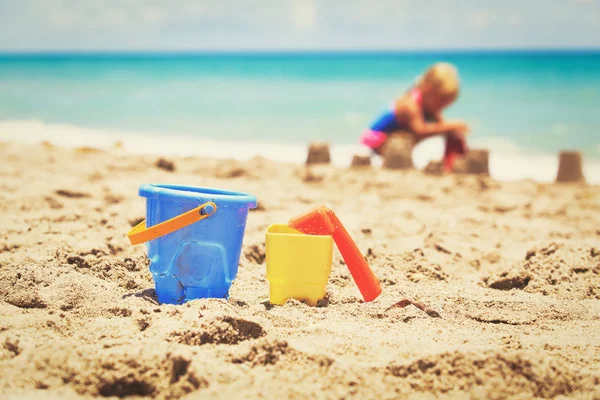 Kids toys and little girl playing on the beach — Stock Photo, Image