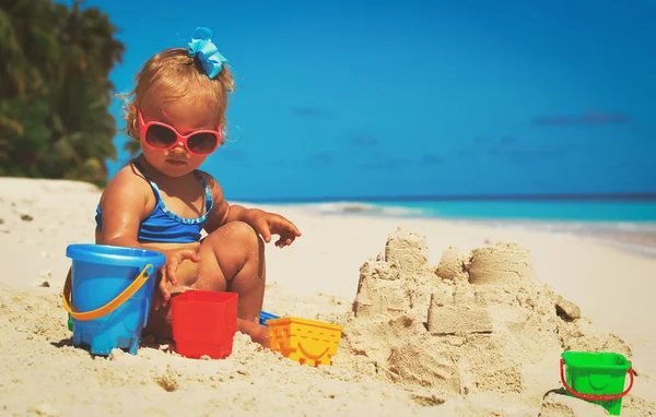 Schattig klein meisje spelen met zand op het strand — Stockfoto