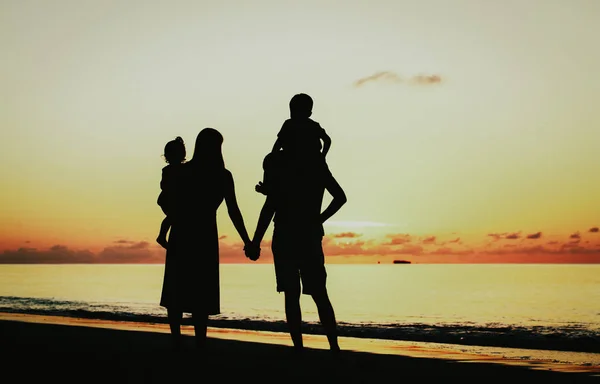 Ευτυχισμένη οικογένεια με δύο παιδιά, τη διασκέδαση στο ηλιοβασίλεμα — Φωτογραφία Αρχείου