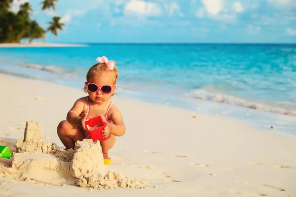 Schattig klein meisje spelen met zand op het strand — Stockfoto
