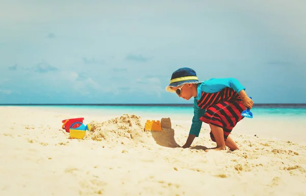 Kleine jongen spelen met zand op strand — Stockfoto